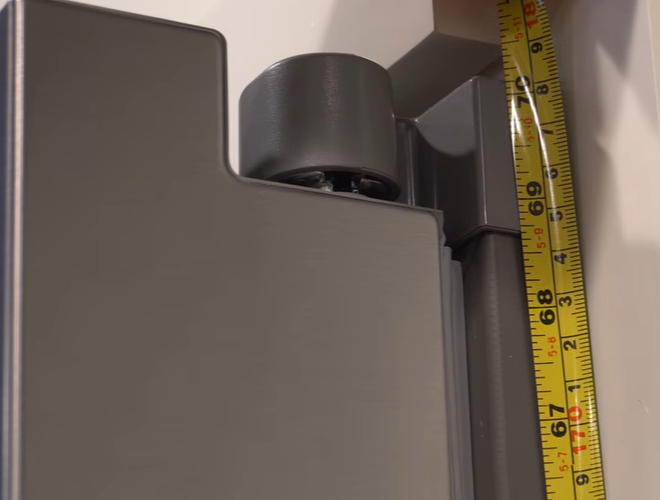 Tape measure beside the upper refrigerator door hinge